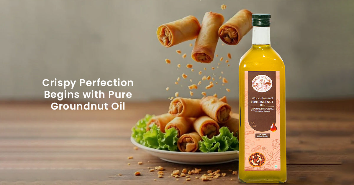 Wood pressed groundnut oil bottle with crispy fried spring rolls on table